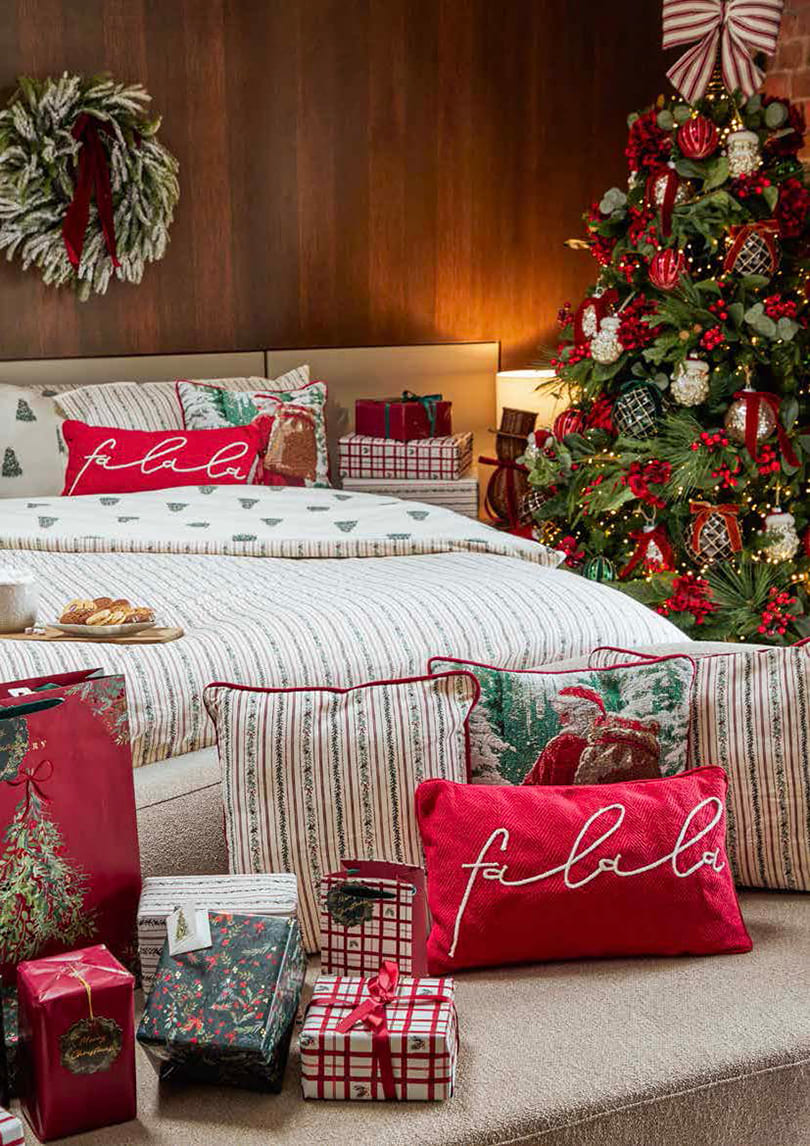 Festive cushions and Christmas bedding beside a decorated tree